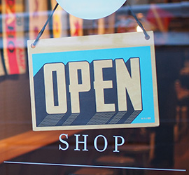 open sign behind a store glass window